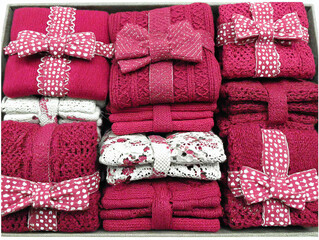 Bundles of warm knitted clothing in vibrant pink hues arranged neatly for a cozy winter collection display