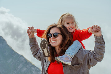 A young mother with her three-year-old child daughter goes to the mountains on Krasnaya Polyana in...