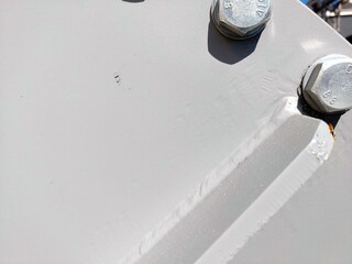 Close-up of Metallic Flange With Bolts and Nuts in Industrial Setting During Daylight Hours