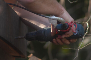man building his hut with tools