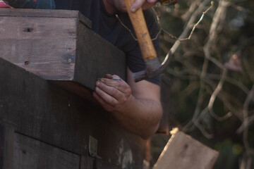man building his hut with tools