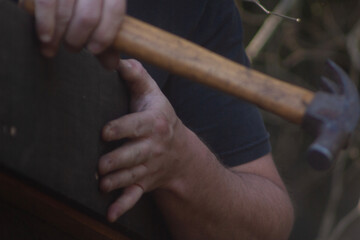 man building his hut with tools