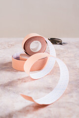 Modern trend against aging and wrinkles kinesio tape in a roll on the table vertical view