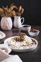 Ice cream sprinkled with chocolate chips and nuts on a plate on the table vertical view