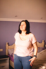 Woman standing in the bedroom while waking up