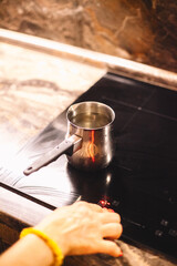Woman boiling water to make coffee