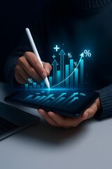 A person interacts with a tablet displaying data visualization graphics, symbolizing progress and financial growth. The dynamic digital interface offers insights into business.