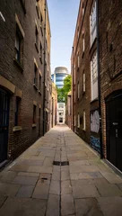 Fototapete Exploring the historic streets of london a walk through a narrow brick alleyway scene © Focus Gem