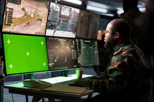 Military early warning systems operator monitoring enemy aerial attacks using green screen satellite equipment. Army soldier in headquarters maintains air space superiority with chroma key radar