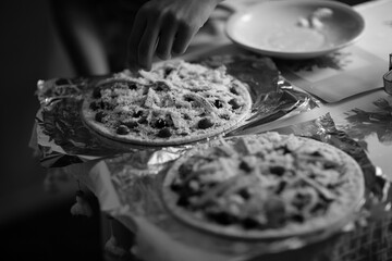Fresh, just cooked pizza pizza with tomatoes, cheese and olives on a wooden table, at home in the...