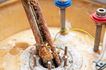 Corrosion and mineral deposits on the heating element of an electric boiler. Boiler maintenance and repair