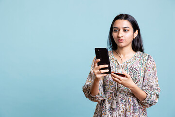 Upbeat person adding banking credentials on her mobile phone, confirming payment and money transfer...