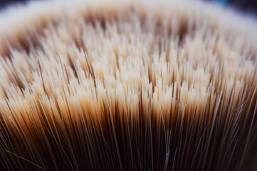 Close-up view of a shaving brush's densely packed, light brown bristles, showcasing their texture and individual strands.