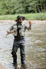 Fisherman casting line in river, enjoying trout fishing adventure