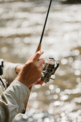 Fisherman holding fishing rod, waiting for trout to bite