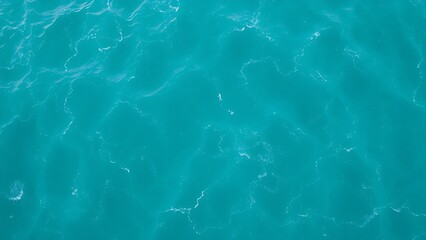 Obraz premium Aerial view of turquoise ocean waves forming abstract patterns, embodying a minimalist summer seascape.