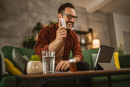 Adult man sit on sofa have consultation via video call about medicines