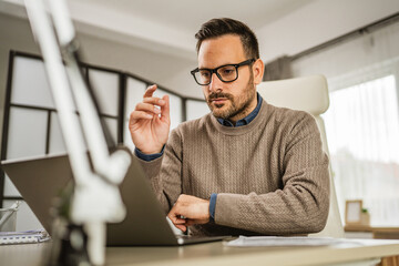 One adult man sit at office and look, read document on laptop at office
