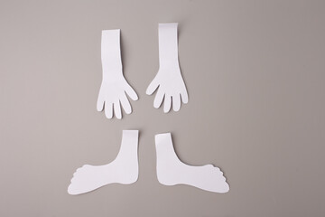 cut-out paper shapes laid out on a flat surface. There are two hands, two feet. beginnings of a paper skeleton craft project, classroom activity or Halloween decoration