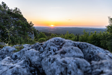 Close-up of limestone rocks at sunset with scenic blurred forest view in the background, Poland