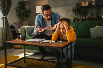 exhausted father help son to finish his homework