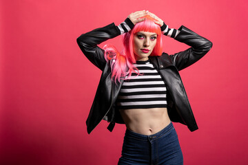 Trendy model with pink hair and bold jacket embraces confident rocker style against isolated...