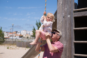 Grandfather Helping His Granddaughter Climb Up a Rope