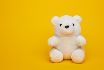 White teddy bear on a yellow
