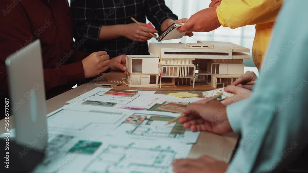 Poster a dynamic group of architects and designers engage in a creative session, discussing building plans 