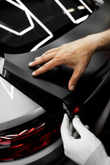 Manual vinyl cutting for perfect fitment and clean visual results. Vinyl Application in Progress in detailing. Vinyl film is trimmed with sharp blade to ensure seamless edges without gaps or tears.