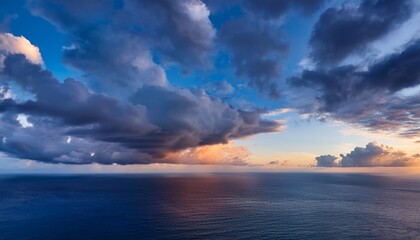 cloud formations above the ocean during day and dusk contrast beautifully in the sky