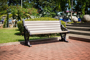 A peaceful scene featuring a wooden bench in a vibrant park setting. The tranquil atmosphere invites relaxation and reflection, offering a serene escape amidst lush greenery and natural beauty.
