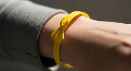 Yellow Ribbon Bracelet on a Wrist, Symbol of Awareness and Support