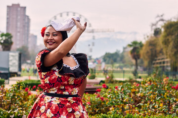 Portrait of a beautiful, smiling young woman, happily dressed in a Chilean huasa, celebrating,...
