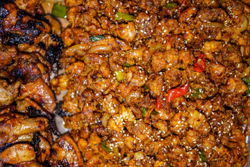 A flavorful dish of glazed and grilled chicken pieces, infused with aromatic onions, peppers, and topped with sesame seeds. This enticing view promises a delicious culinary experience.