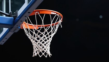 Closeup of basketball hoop with white net, orange rim against dark background. This indoor sports equipment, often found in gyms or arenas, is ready for scoring. Isolated detail shot.