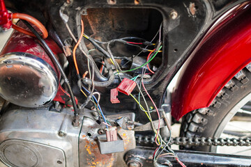 An up-close shot highlights the inner workings of a motorcycle, showing colorful wiring, engine...