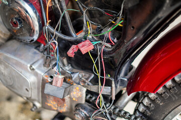 Close-up of a motorcycle's exposed engine area showcases complex wiring with vibrant colors,...