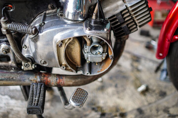 Detailed close-up of motorcycle engine with exposed carburetor, showcasing mechanical components...
