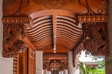 Ornate wooden carvings adorn pillars, showcasing Foo Dogs at Jing'an Temple in Shanghai, China....