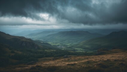 A valley surrounded by hills under dark, cloudy skies with rolling mountains in the distance.