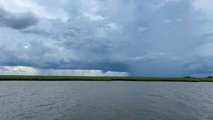 A storm over the land as viewed from the intracoastal waterway with dark clouds and rain