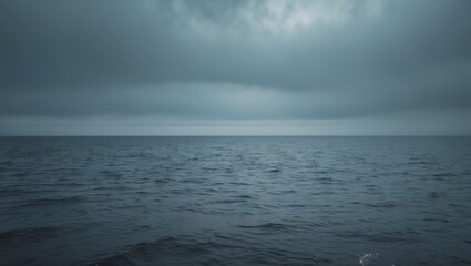 Obraz premium Open ocean under a cloudy sky with an expansive water surface and overcast weather.