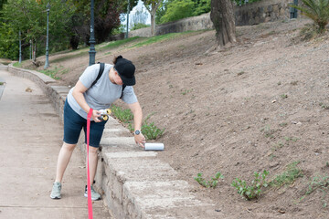 Person Picking Up Empty Cans Left in Park While Walking Dog.