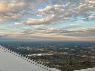Aerial late afternoon view of suburban neighborhoods, roads, and development patterns with partly...