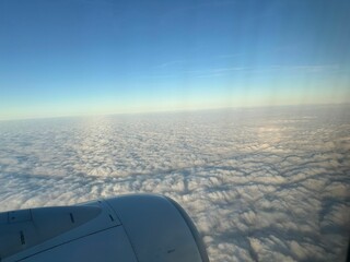 Beautiful fluffy clouds in sky, view through airplane window