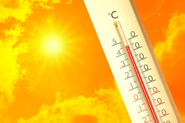Extremely high temperature on thermometer against orange sky on sunny day. Severely hot summer...