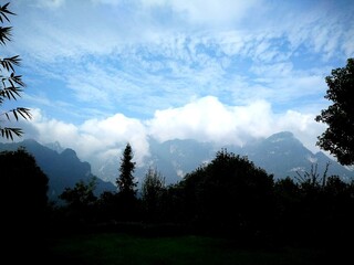 Misty mountain range beneath blue sky and clouds, peaceful nature background