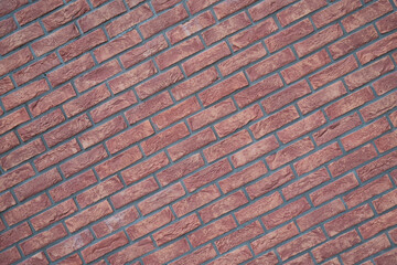 Red brick wall laid diagonally with gray mortar Detailed texture of the bricks and mortar is visible Close up