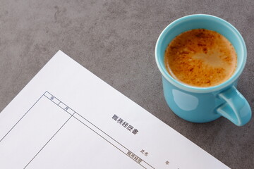 コーヒーを飲みながら、転職活動に欠かせない職務経歴書を準備しているイメージ
